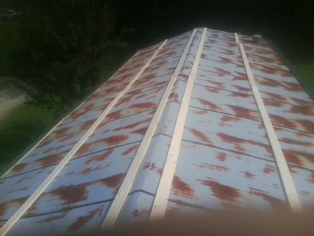 Rusted metal roof panels with new wood purlins before replacement — Storm Damage Roof Repair in Trafford by Roofing Brothers